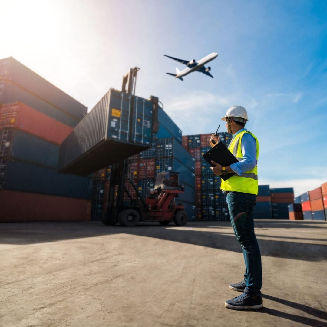Foreman control loading Containers box to truck Worker inspecting cargo containers at shipping port.