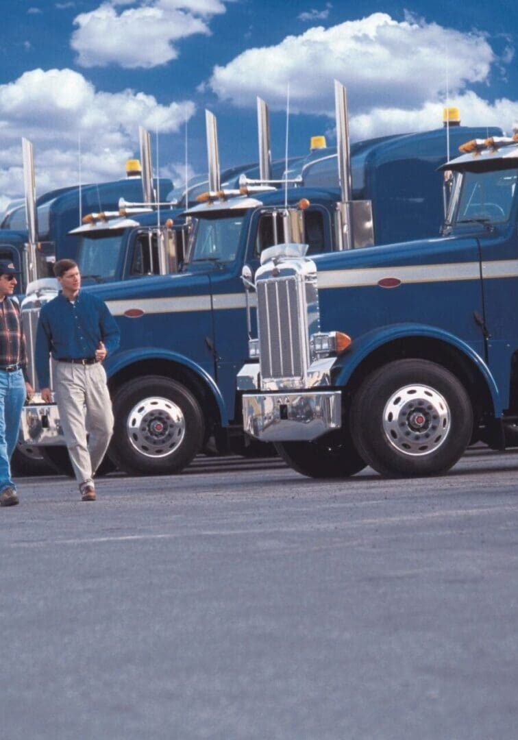fm=f_43878 A row of large trucks parked in front of a man.